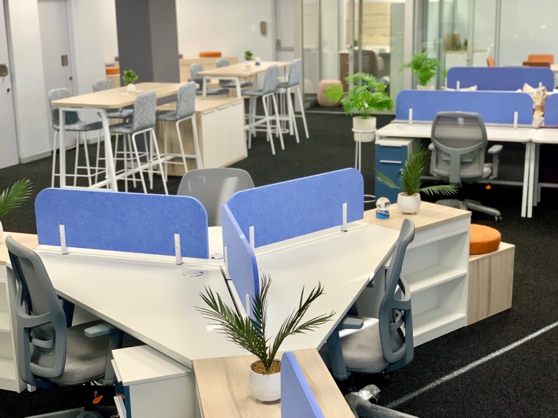 Hybrid office interior with white desking and blue screens